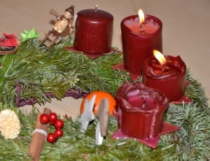 lighted red candle in fir tree wreath thumbnail