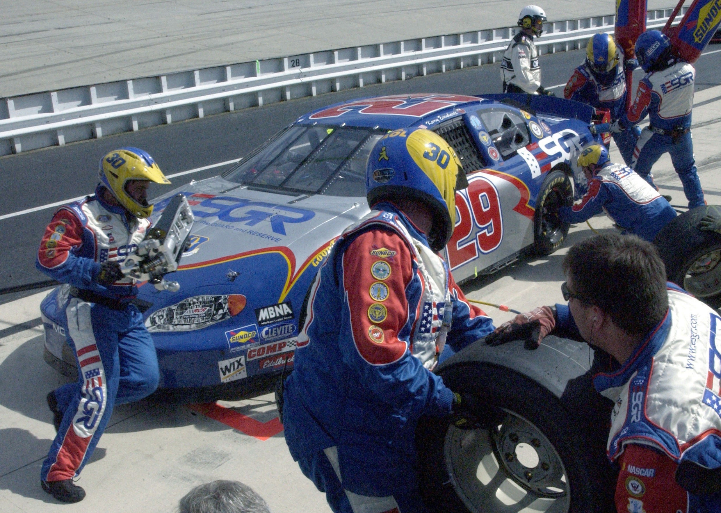 gray and blue nascar car changing tires