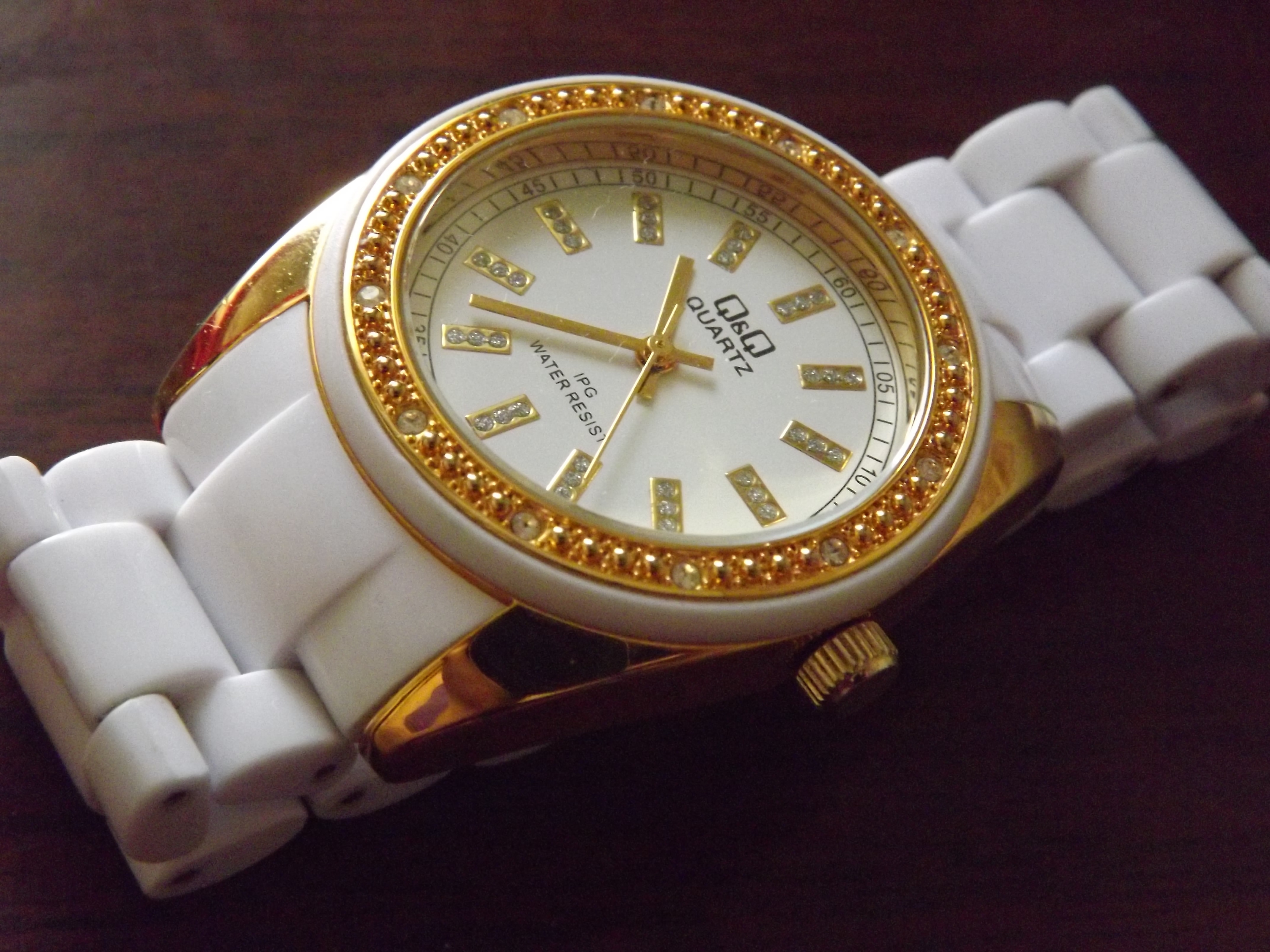 white strap and gold round analog watch