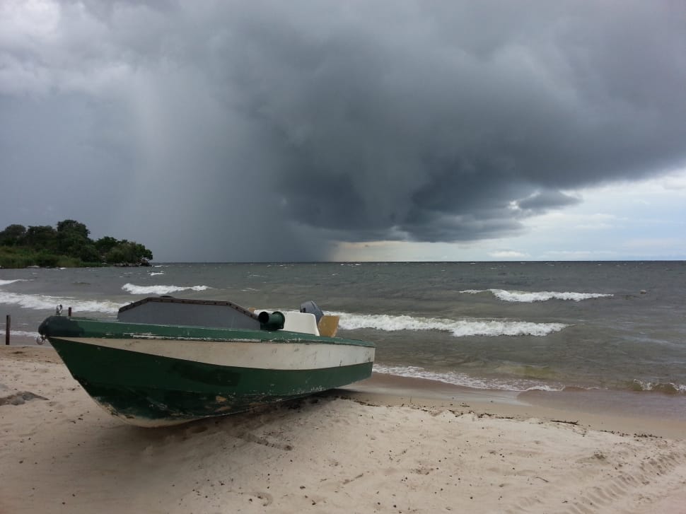 green and white motor boat beside sea during stormy season preview