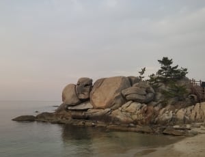 brown stone rocks near in body of water thumbnail