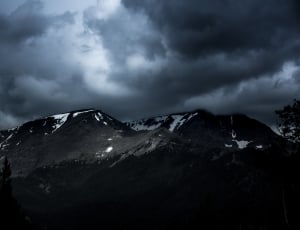 white and gray mountain under cloudy sky during nighttime thumbnail