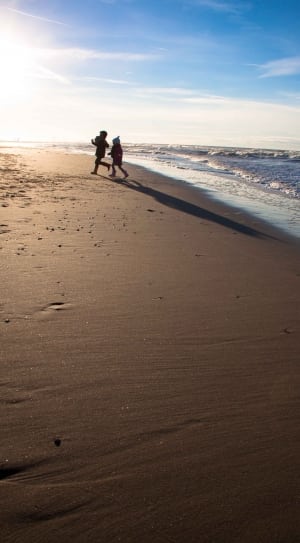 children running on beach shore during daytime thumbnail