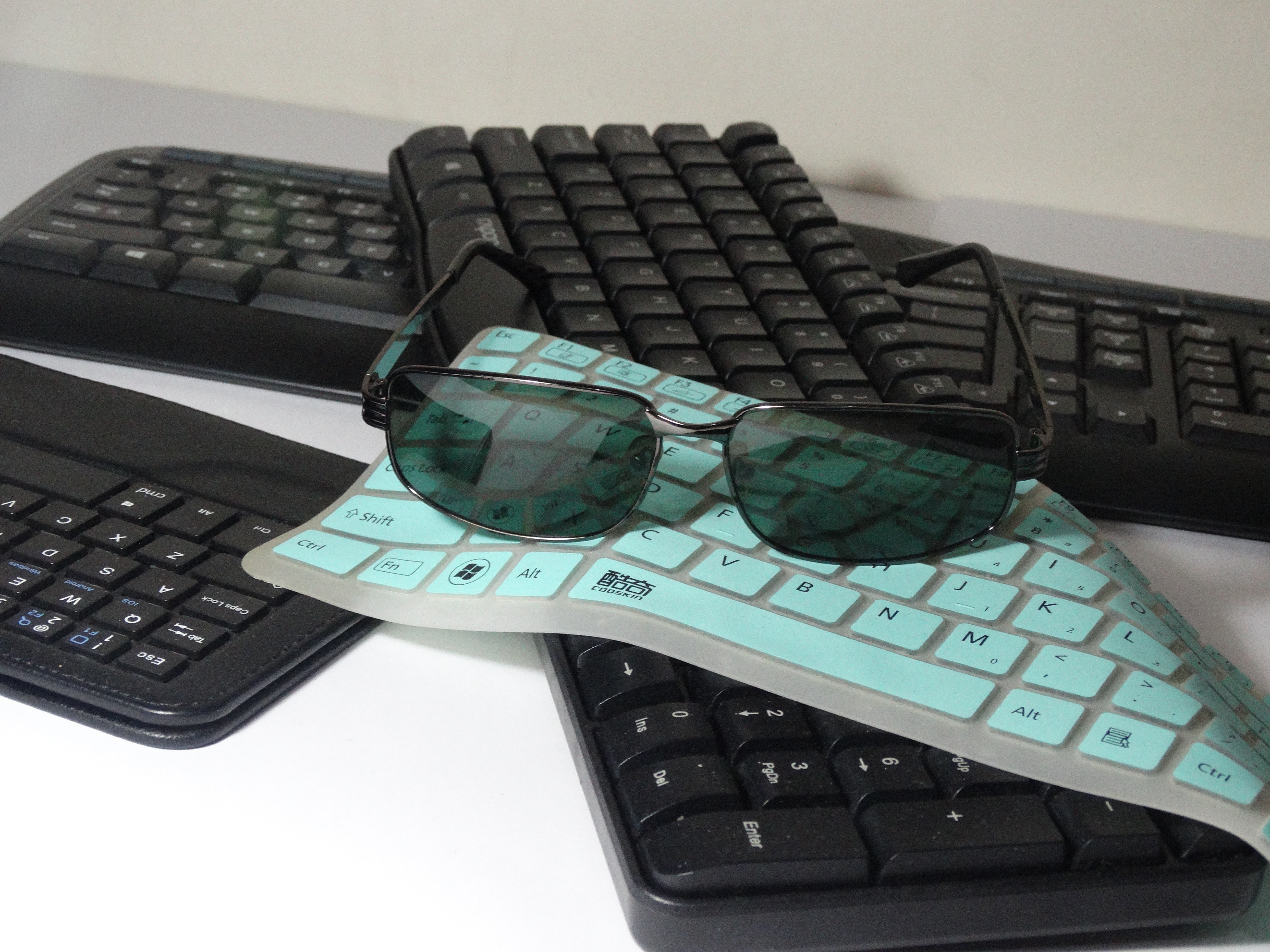 black sunglasses and 3 keyboards