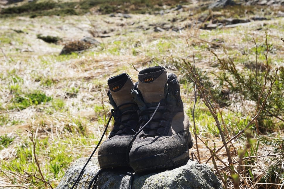 pair of black-and-gray hiking boots on green field during daytime preview