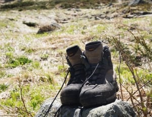 pair of black-and-gray hiking boots on green field during daytime thumbnail