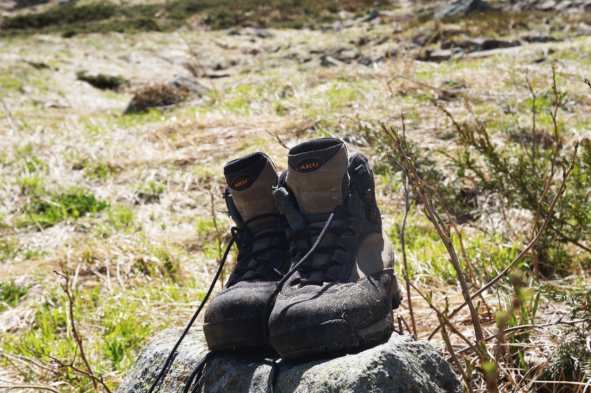 pair of black-and-gray hiking boots on green field during daytime