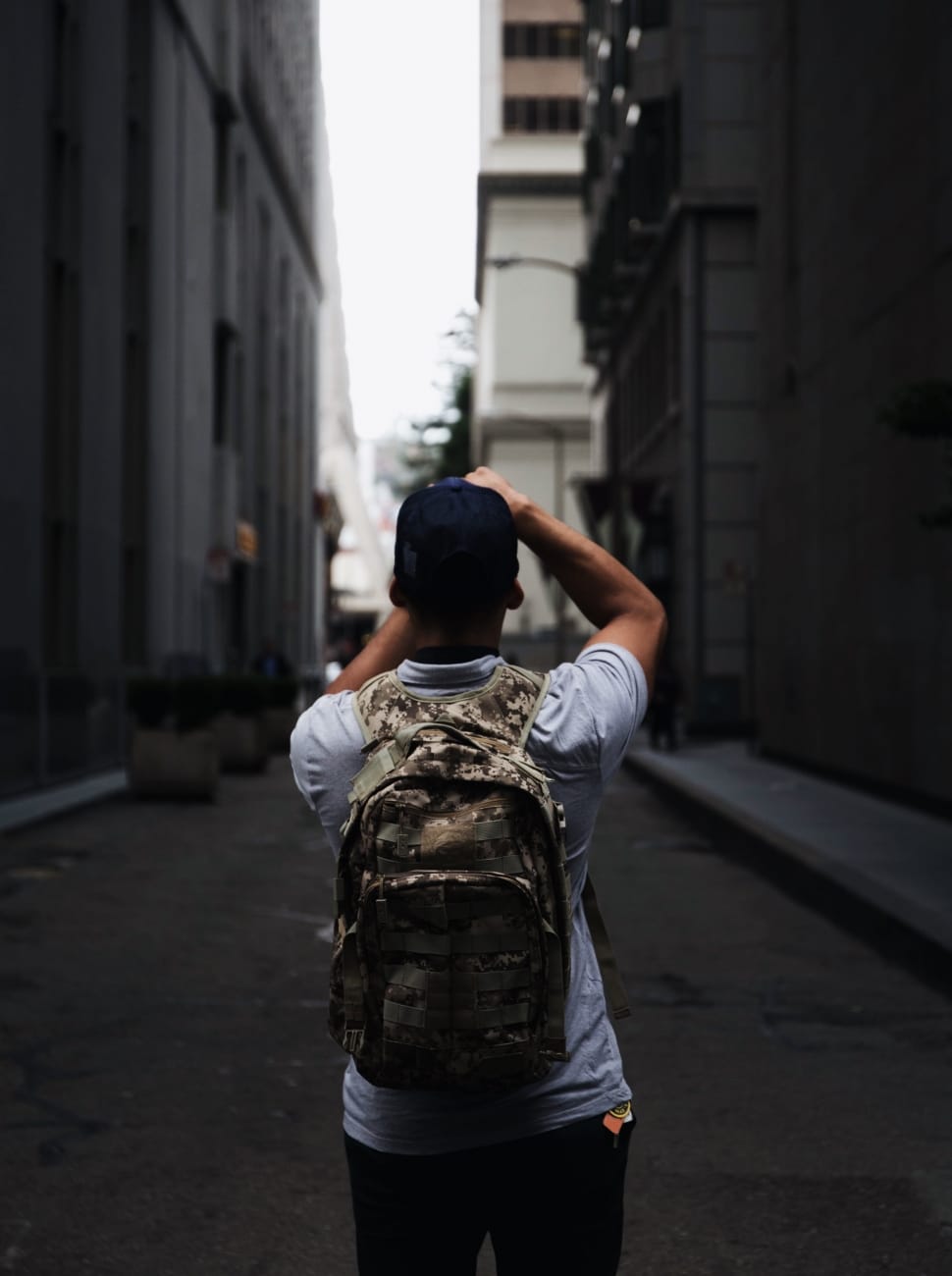 person wearing gray and green camouflage backpack preview
