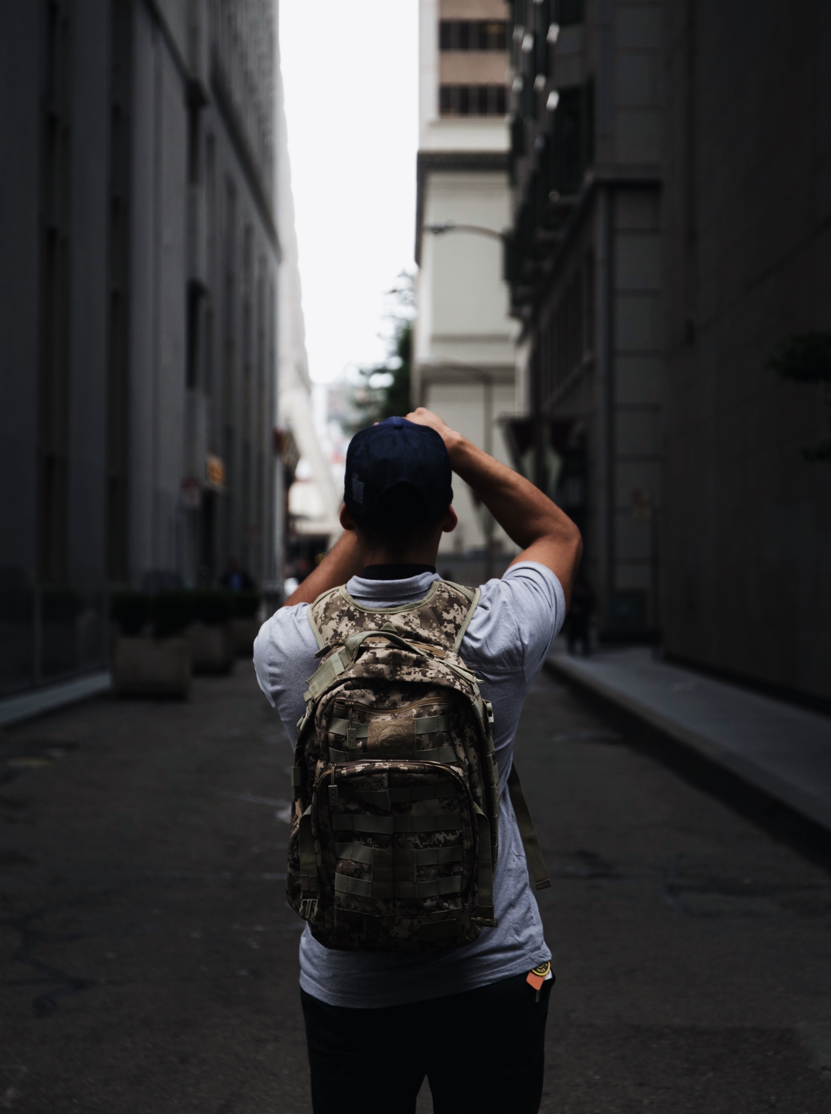 person wearing gray and green camouflage backpack