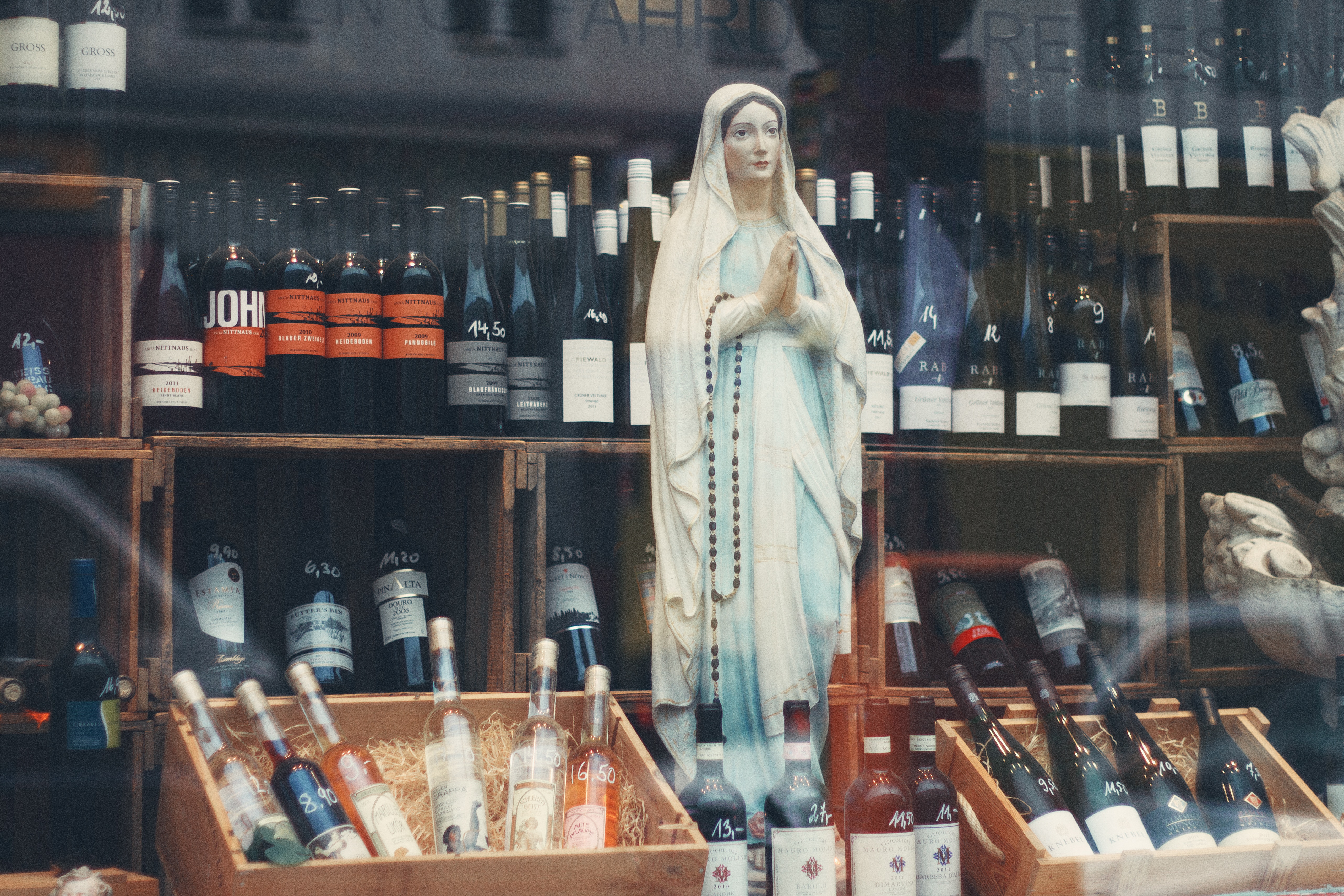 virgin mary figurine in the middle of bottles