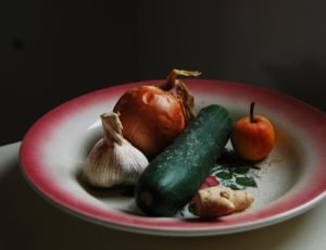 cucumber, garlic, and union on white-and-red ceramic plate thumbnail