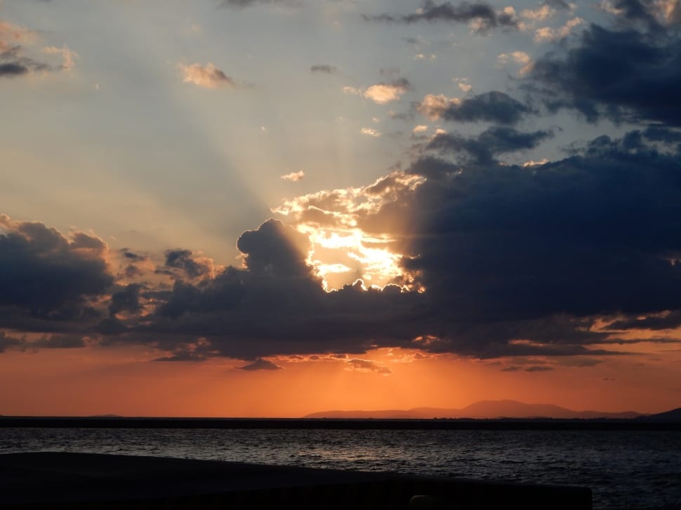 sun setting covered by clouds over the horizon image preview