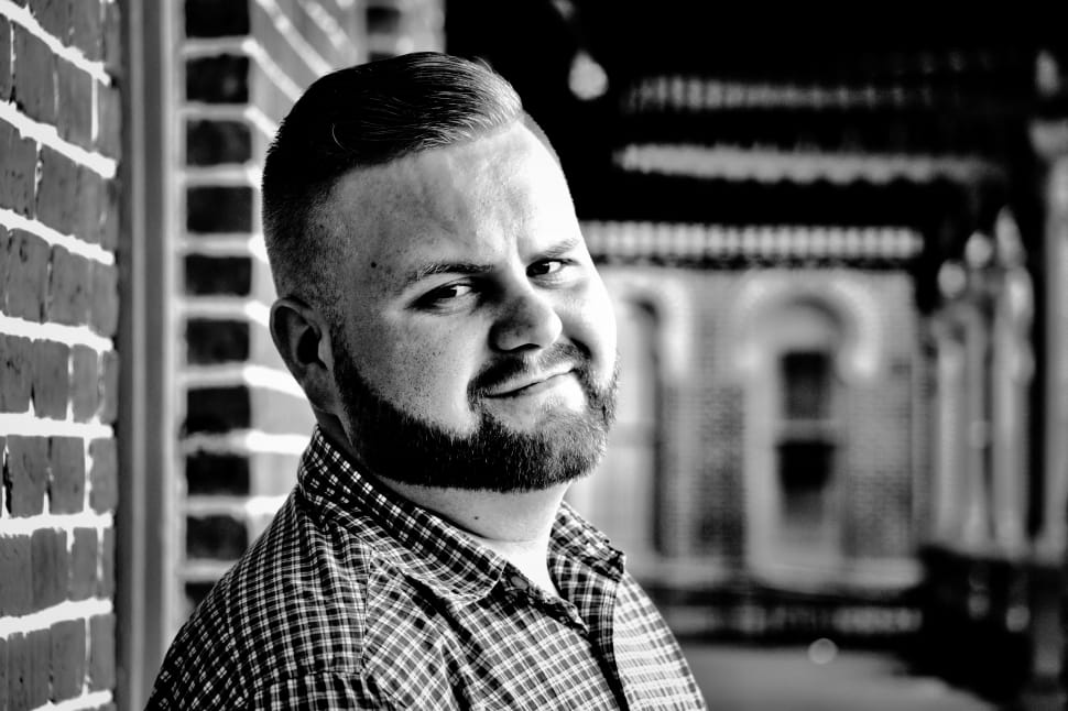 grayscale photo of man near brick wall preview