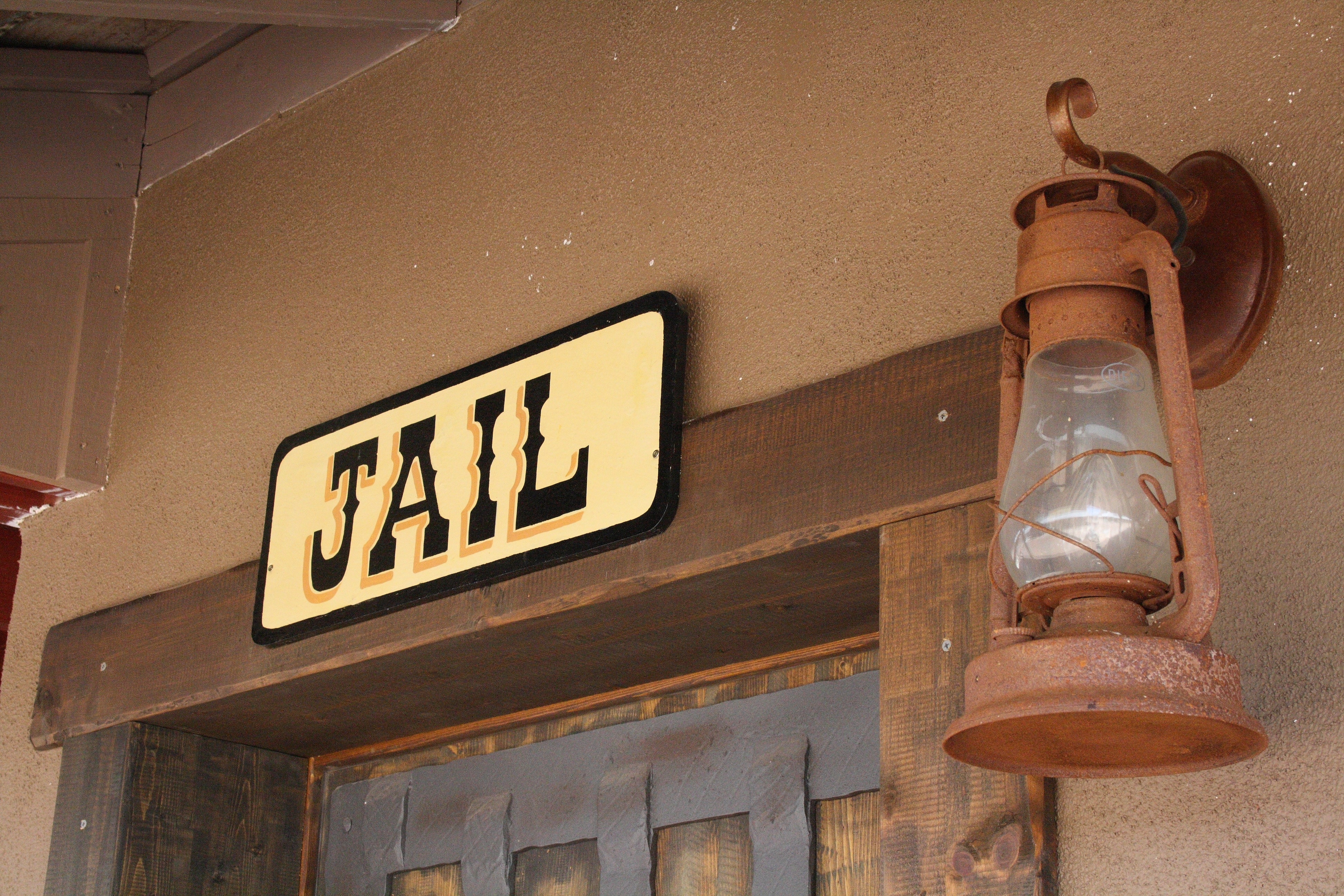 white and black jail signboard and kerosene lamp