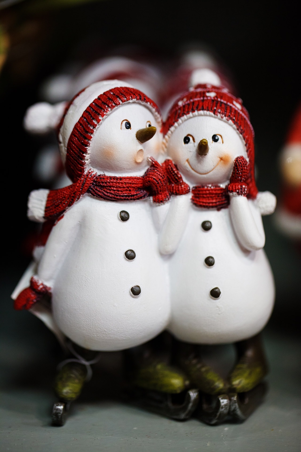 two snowman ceramic figurine on gray surface