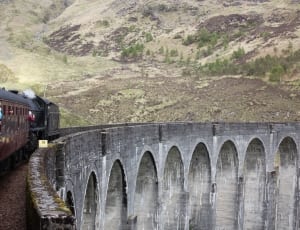 black train and concrete railroad with mountain view photo thumbnail