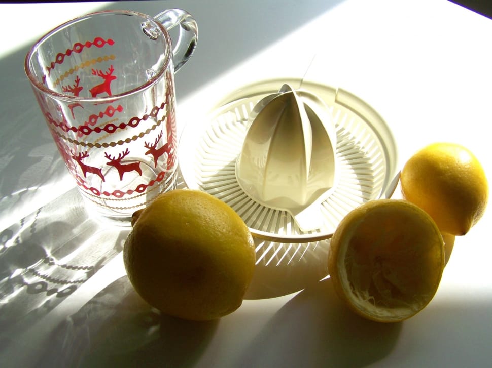 photo of two lemons near juice extractor and clear drinking glass preview