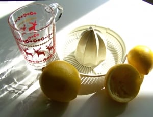 photo of two lemons near juice extractor and clear drinking glass thumbnail