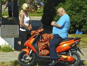 man in blue crew neck t shirt riding on orange motor scooter thumbnail