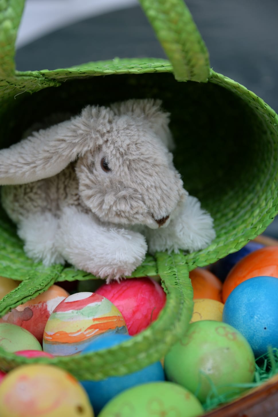 gray bunny plush toy inside green wicker handbag preview