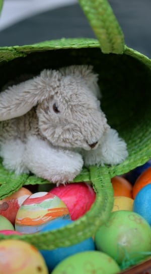 gray bunny plush toy inside green wicker handbag thumbnail