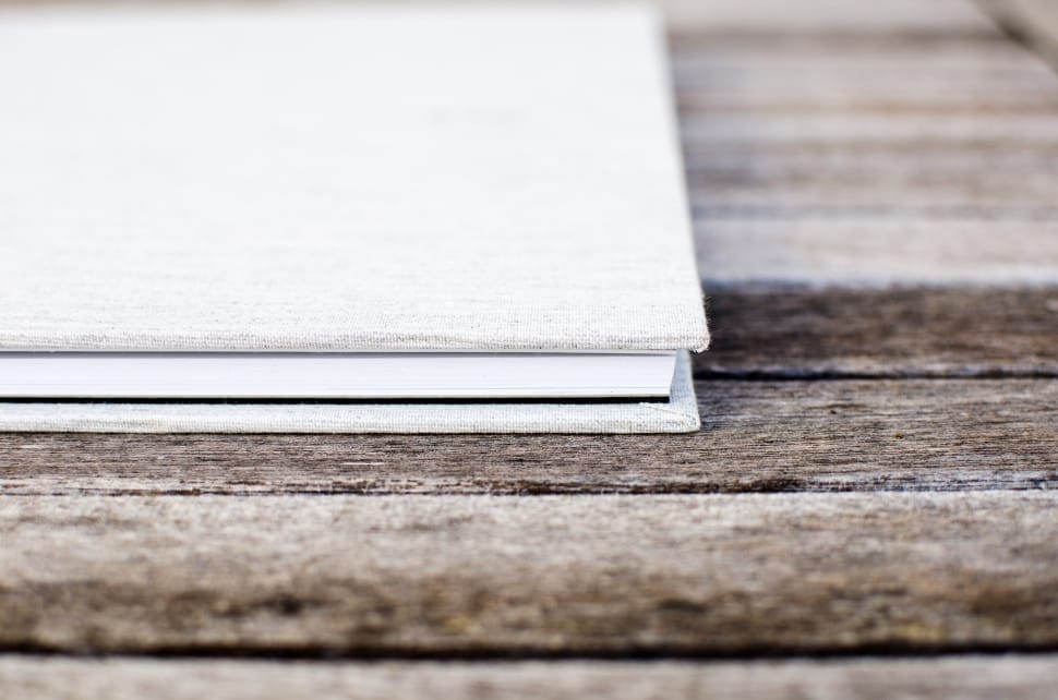 white book on brown wooden surface preview