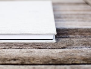 white book on brown wooden surface thumbnail