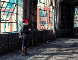 woman in black jacket standing near brown concrete building thumbnail