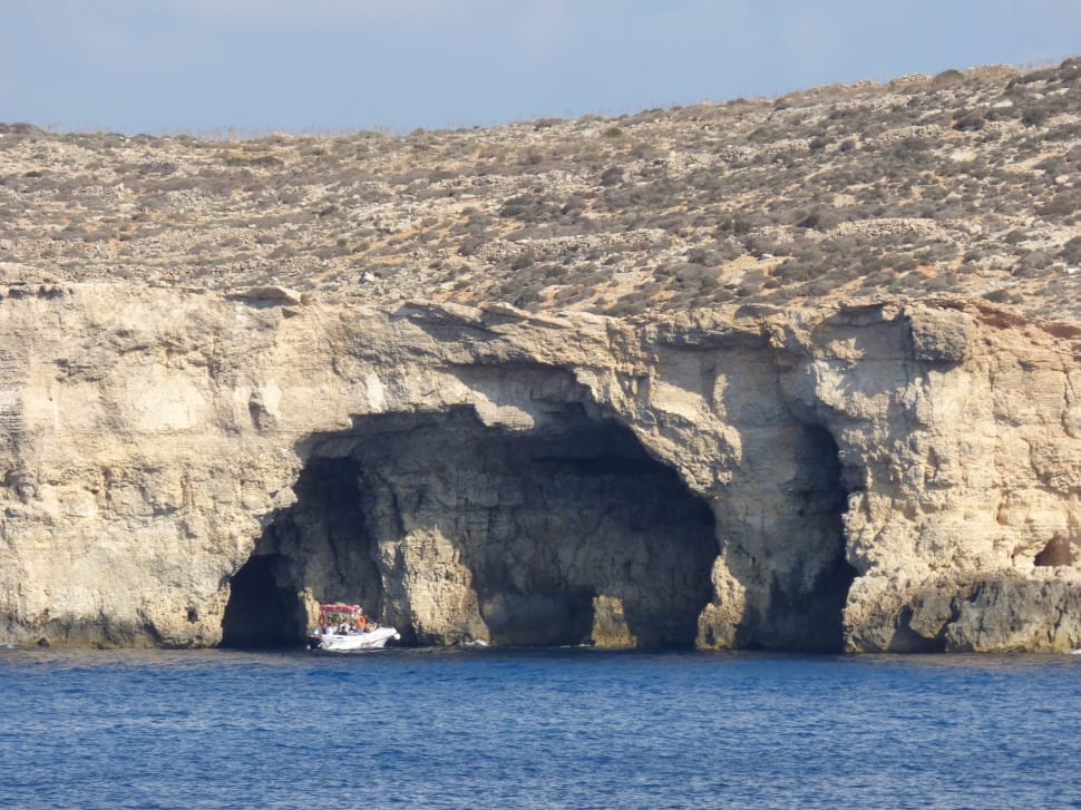 white yacht near rock formation preview