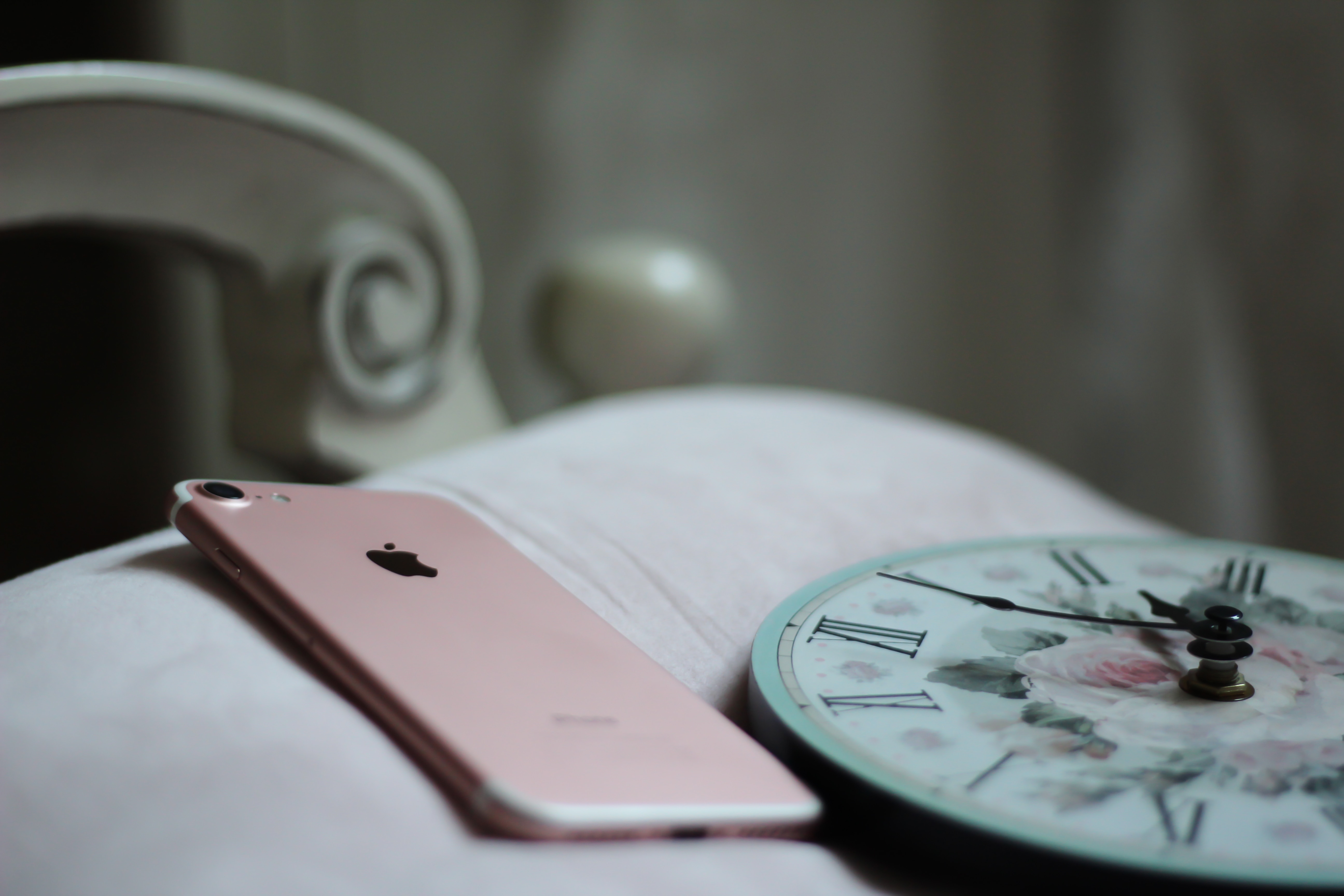 rose gold iphone 6 on white and green analog wall clock