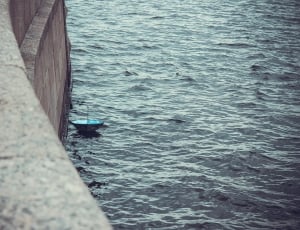 selective focus photography of blue upside down umbrella on body of water thumbnail
