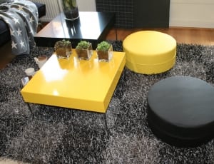 2 black and yellow round ottomans and yellow coffee table thumbnail