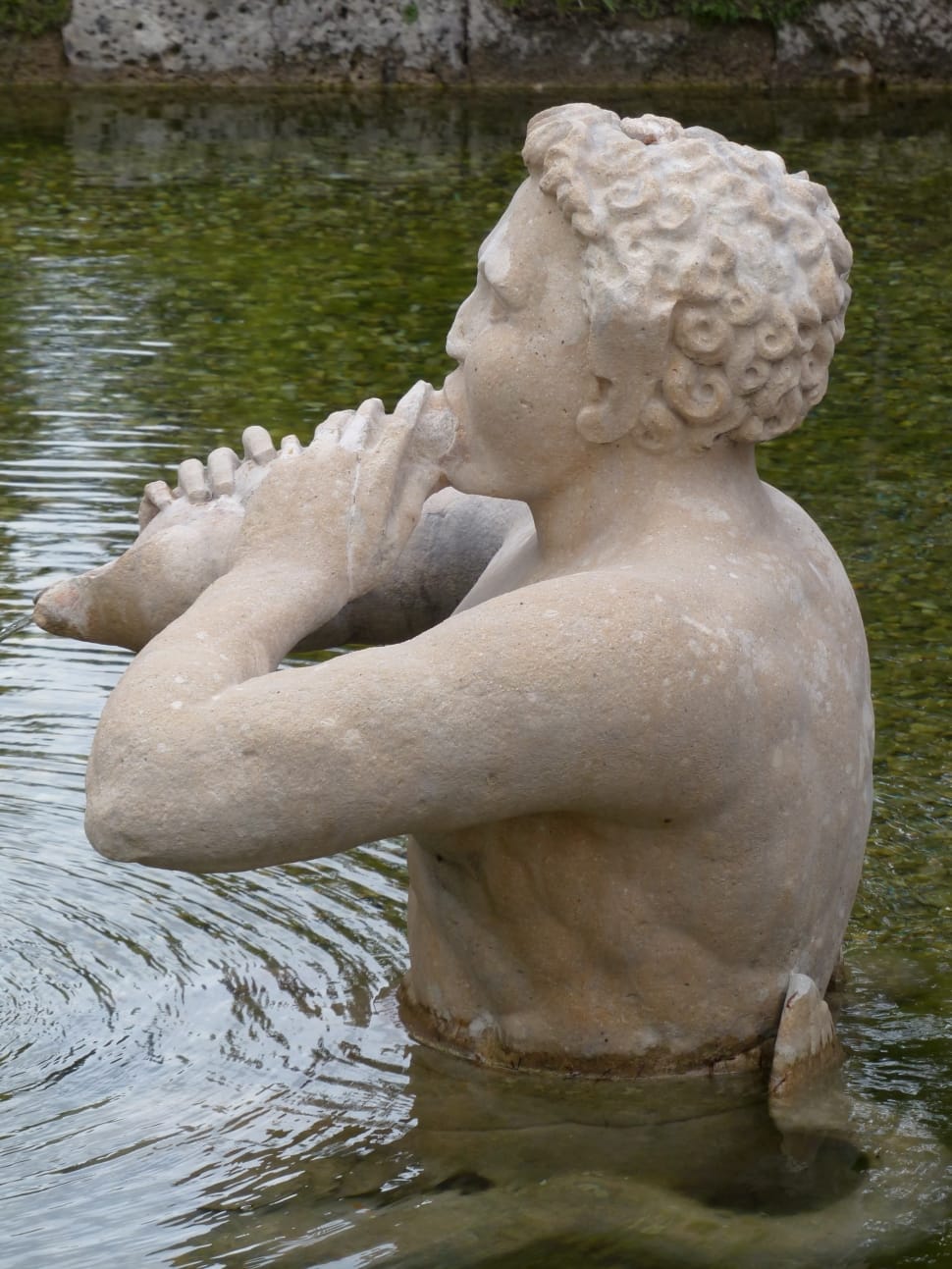 man sculpture on body of water preview