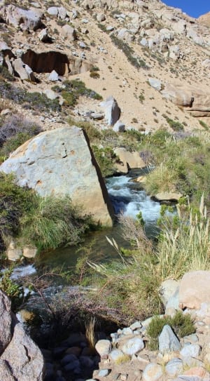 flowing water in the middle of rocky mountain thumbnail