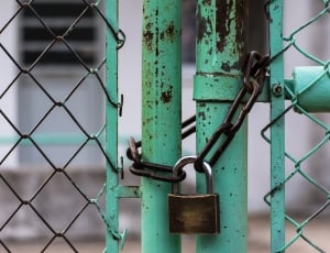 brown padlock on teal steel gate thumbnail