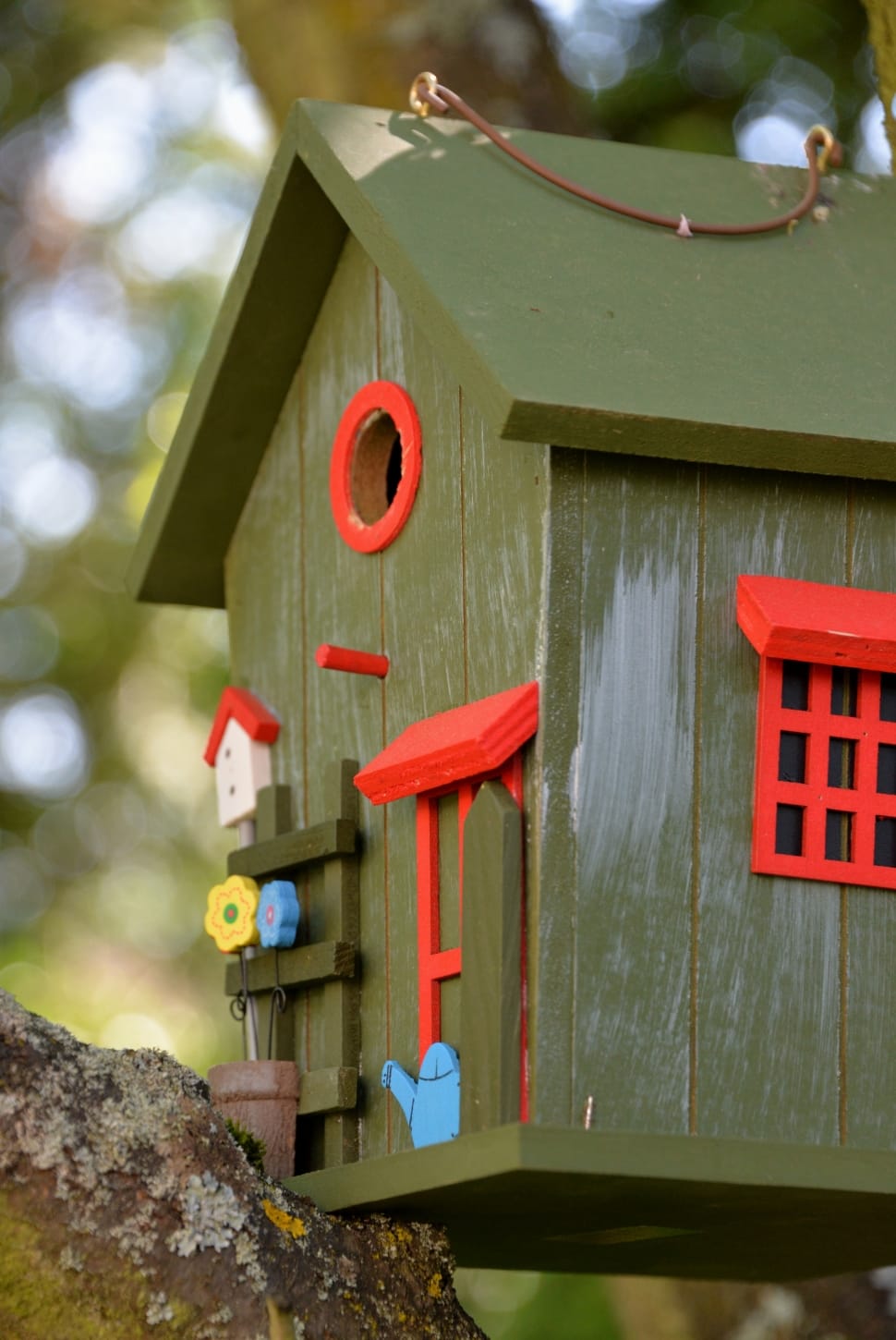 red, blue, and green wooden bird house preview