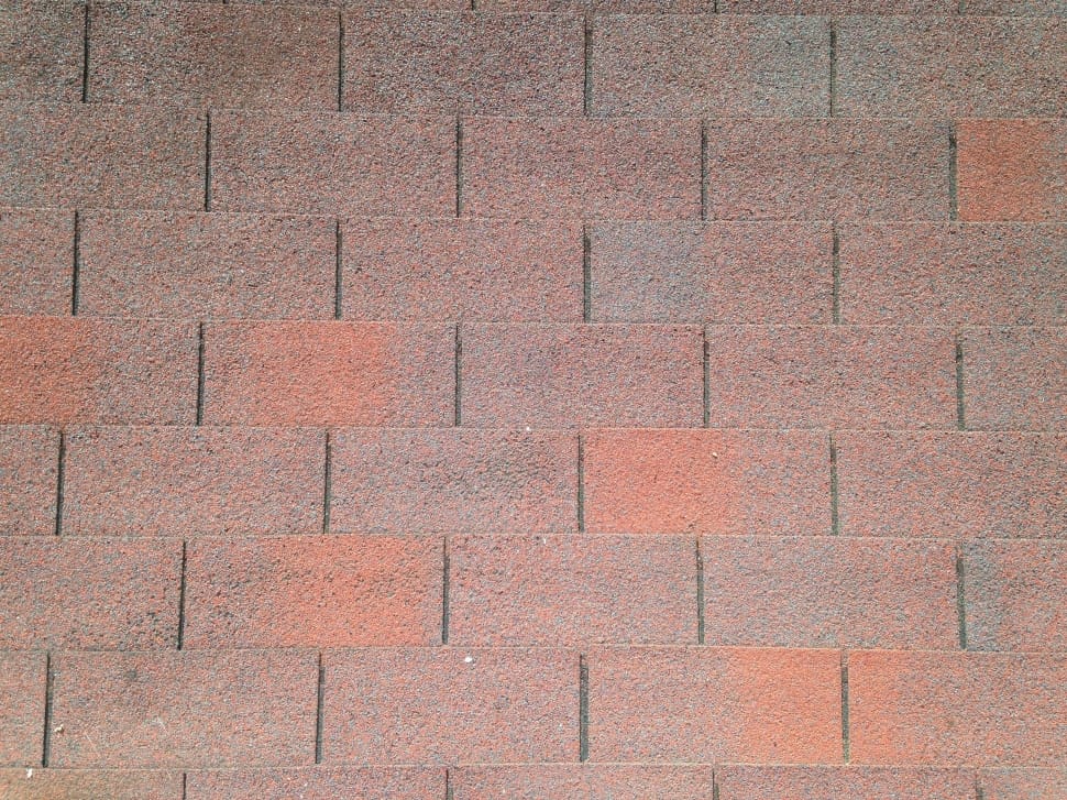 person taking a picture of brown brick surface preview