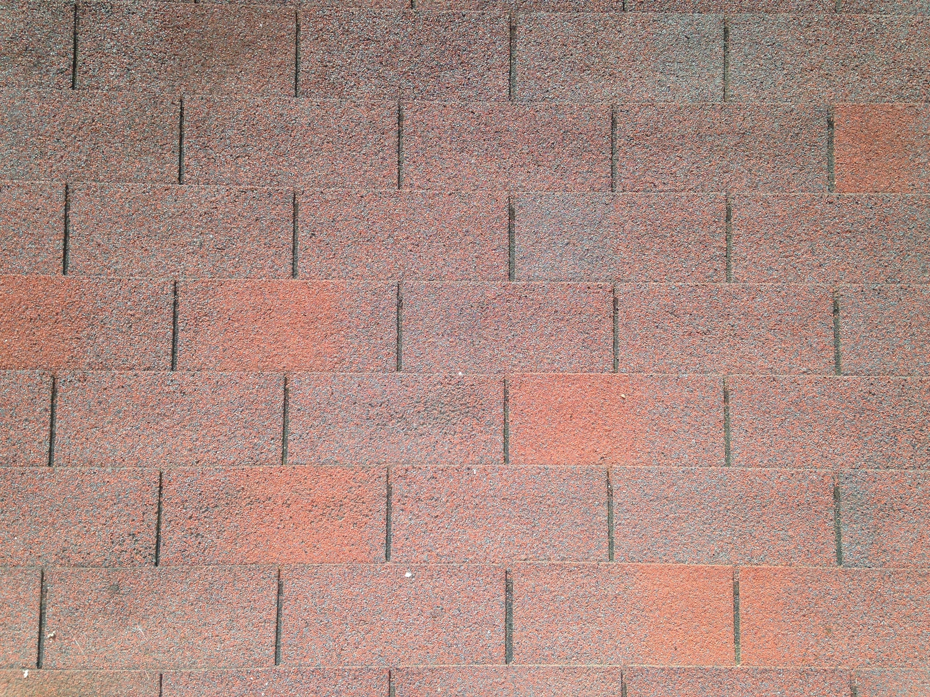 person taking a picture of brown brick surface