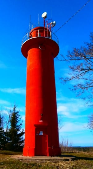 red lighthouse under blue sky during day time thumbnail