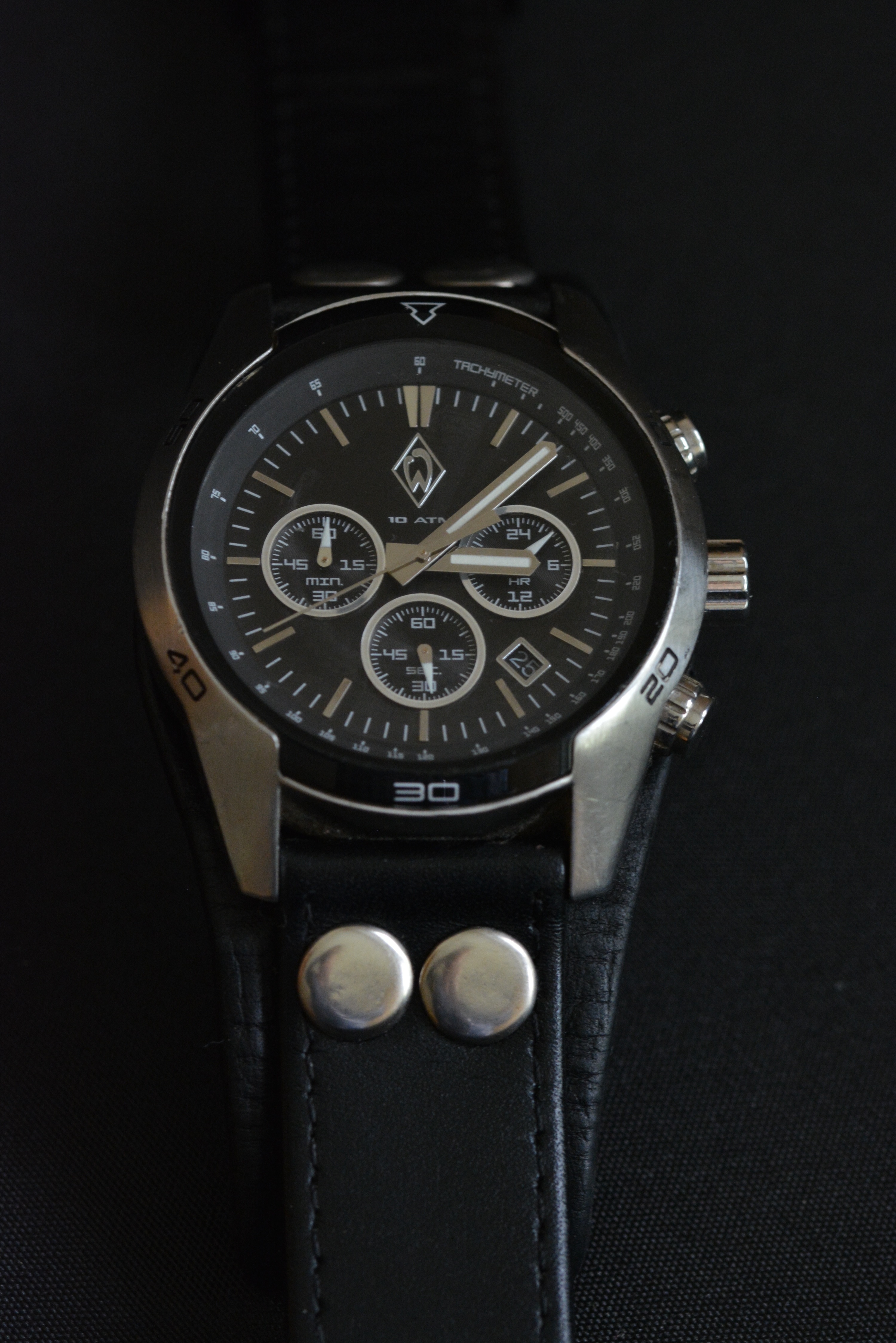 black leather strap black face round chronograph watch