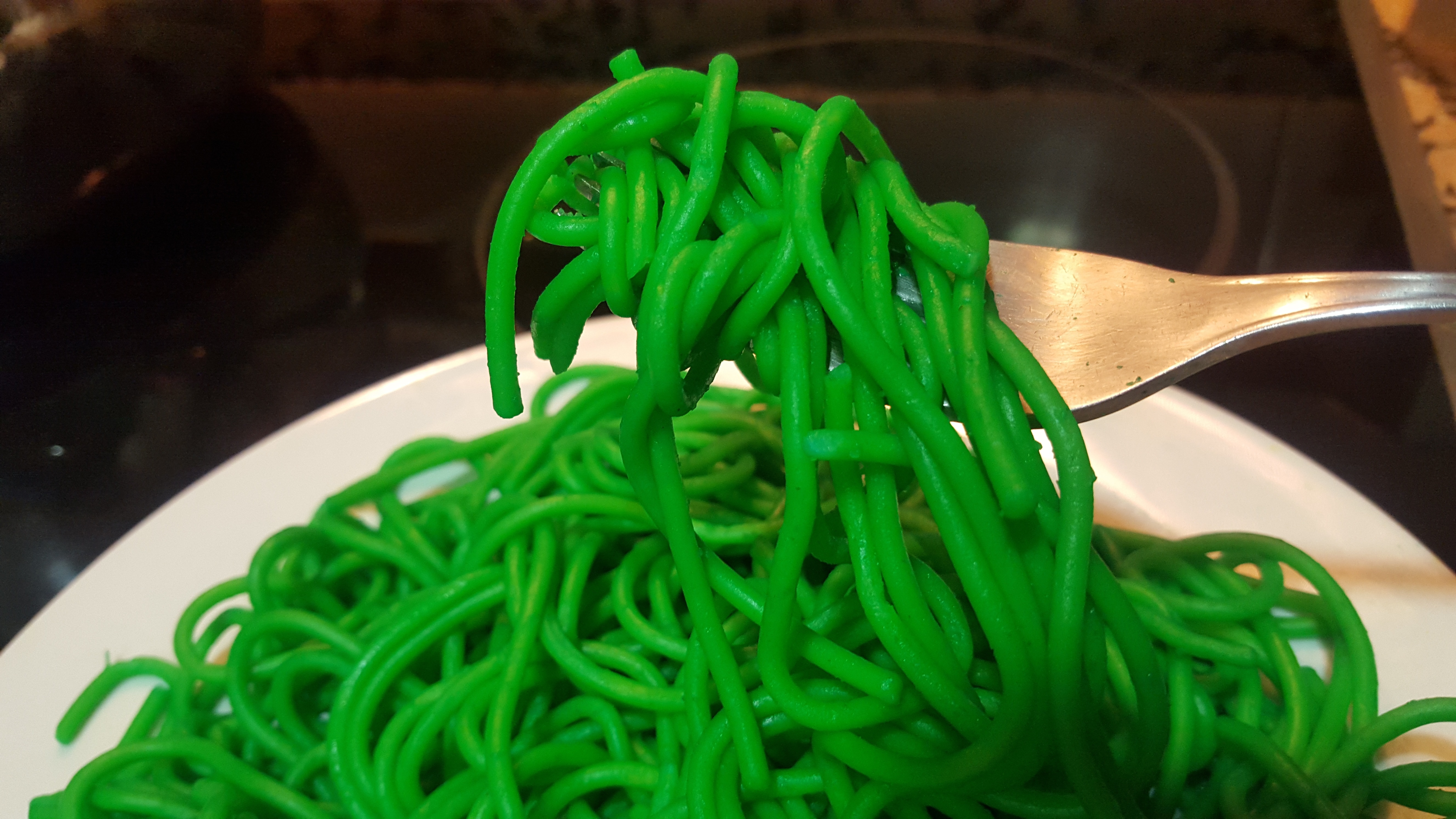 photo of green pasta with fork