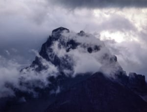 black rocky mountain with white clouds thumbnail