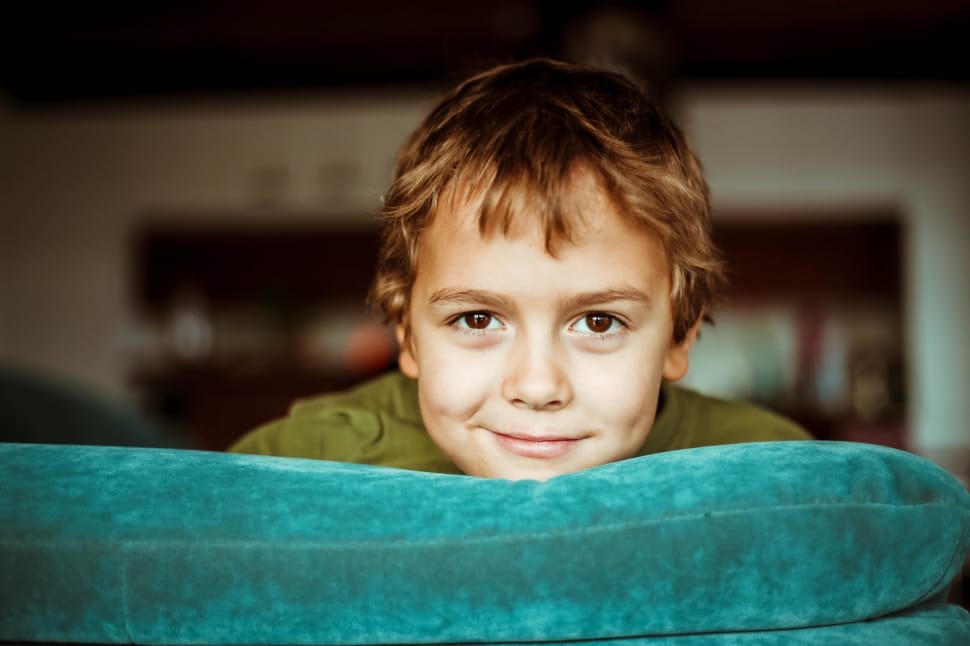 boy in green shirt on green padded sofa preview