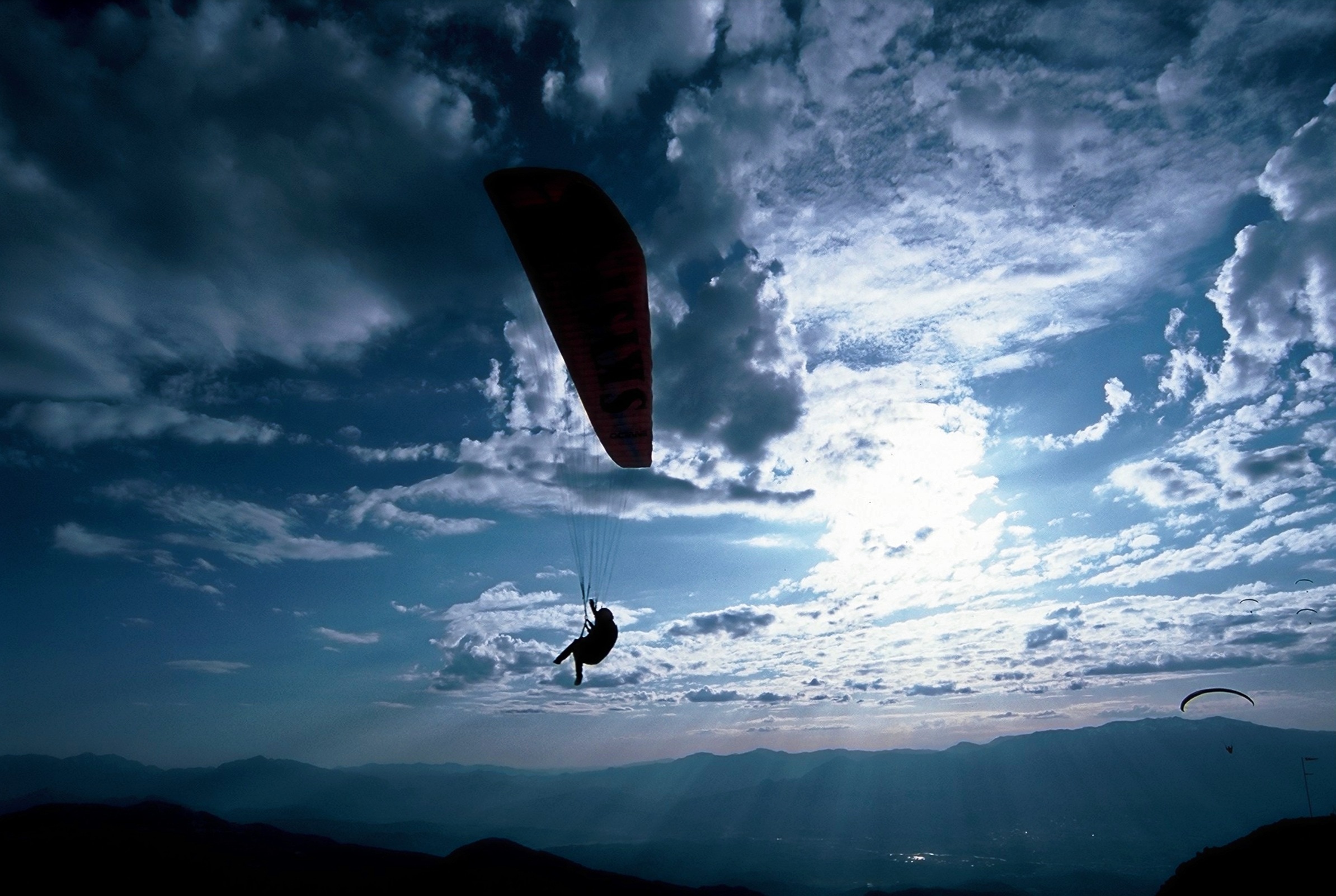 silhouette of person paragliding