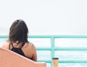 woman sitting near ocean during daytime thumbnail