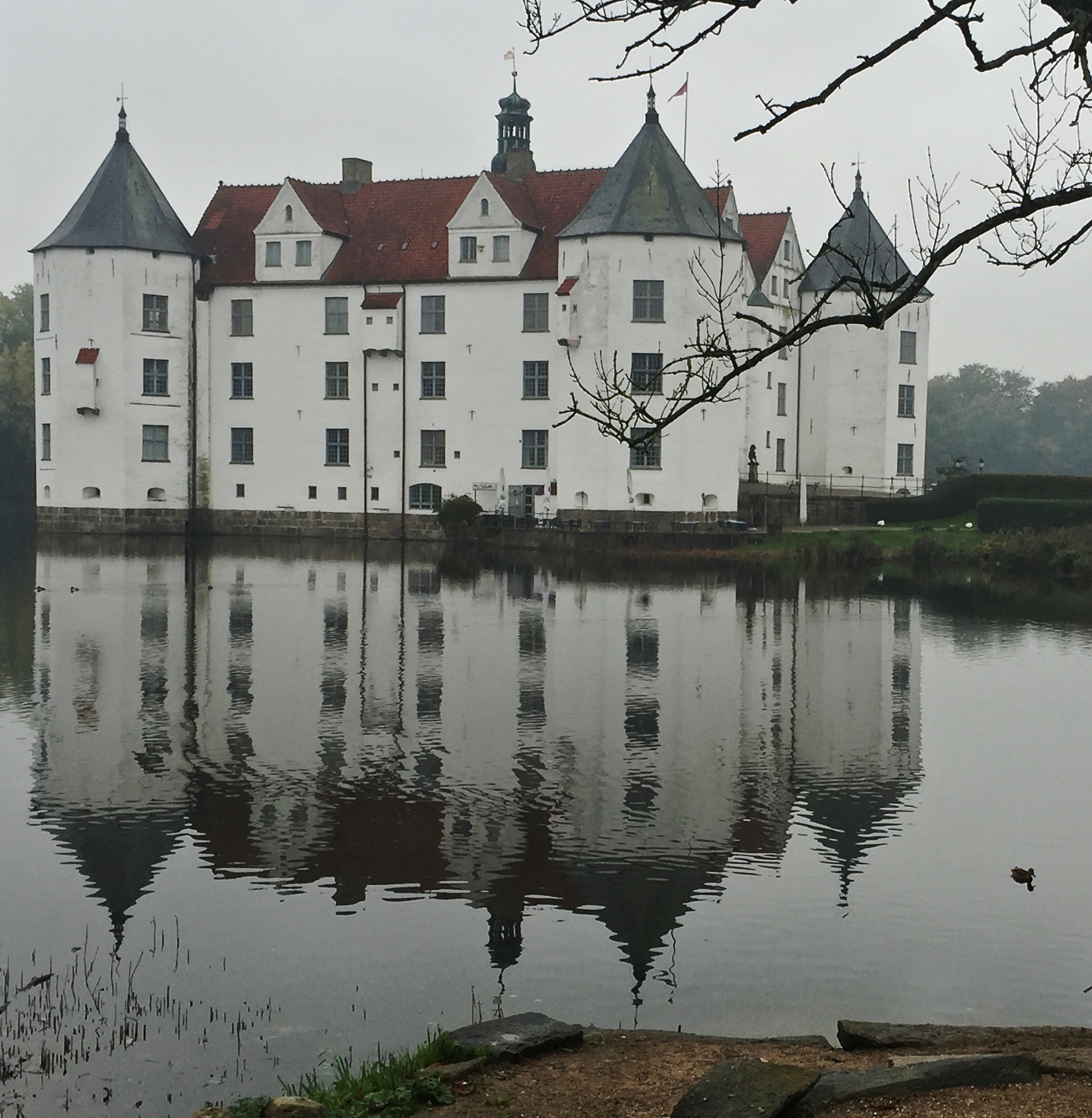 white and maroon concrete castle near body of water
