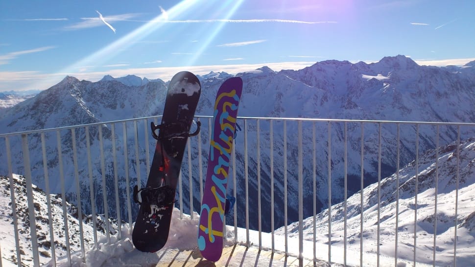 2 purple and black snowboard and snow capped mountain preview