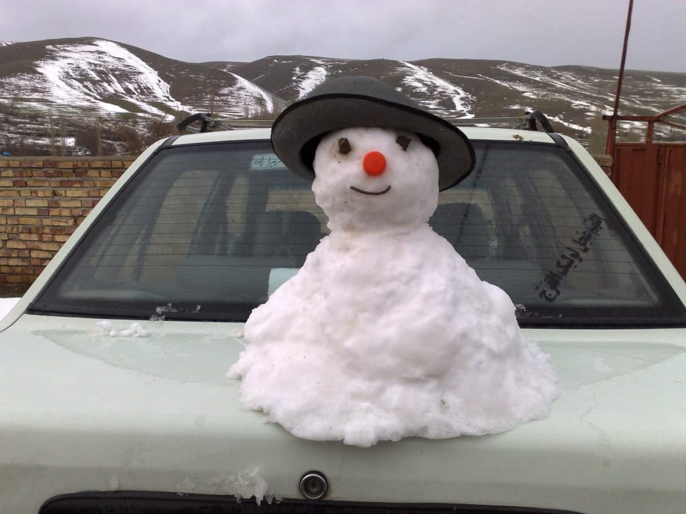 white snow man on top of white sedan preview