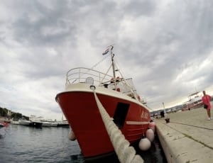 low angled photo of red and white cruise ship on dock side area thumbnail
