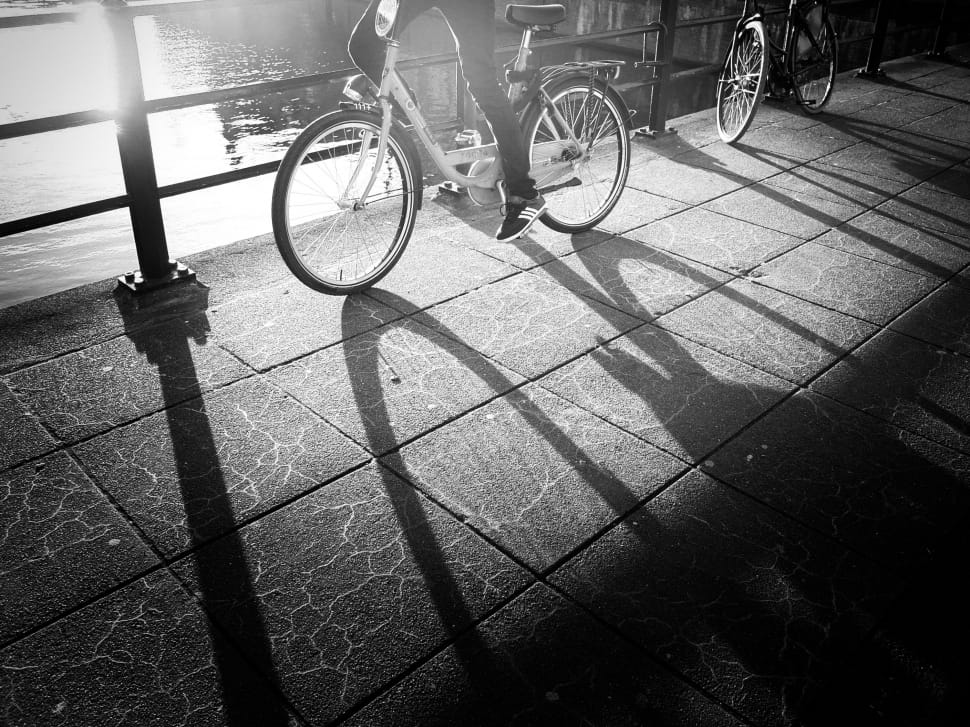 grayscale photography of person riding on city bike preview